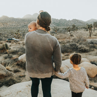 mom with her kids standing on rock